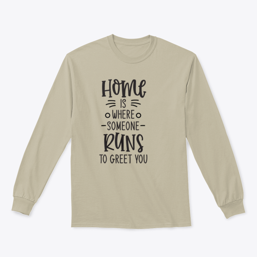 A cozy lettering design that reads 'Home Is Where Someone Runs To Greet You' on a soft cotton fabric, perfect for home or casual wear.