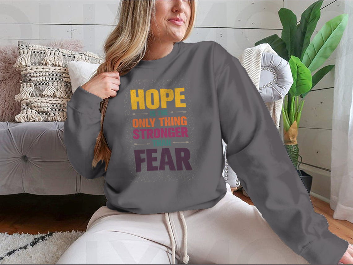A stylish t-shirt featuring the inspirational quote 'Hope Is The Only Thing Stronger Than Fear' in a classic fit, made from a comfortable cotton-polyester blend.