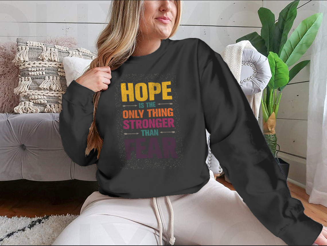 A stylish t-shirt featuring the inspirational quote 'Hope Is The Only Thing Stronger Than Fear' in a classic fit, made from a comfortable cotton-polyester blend.