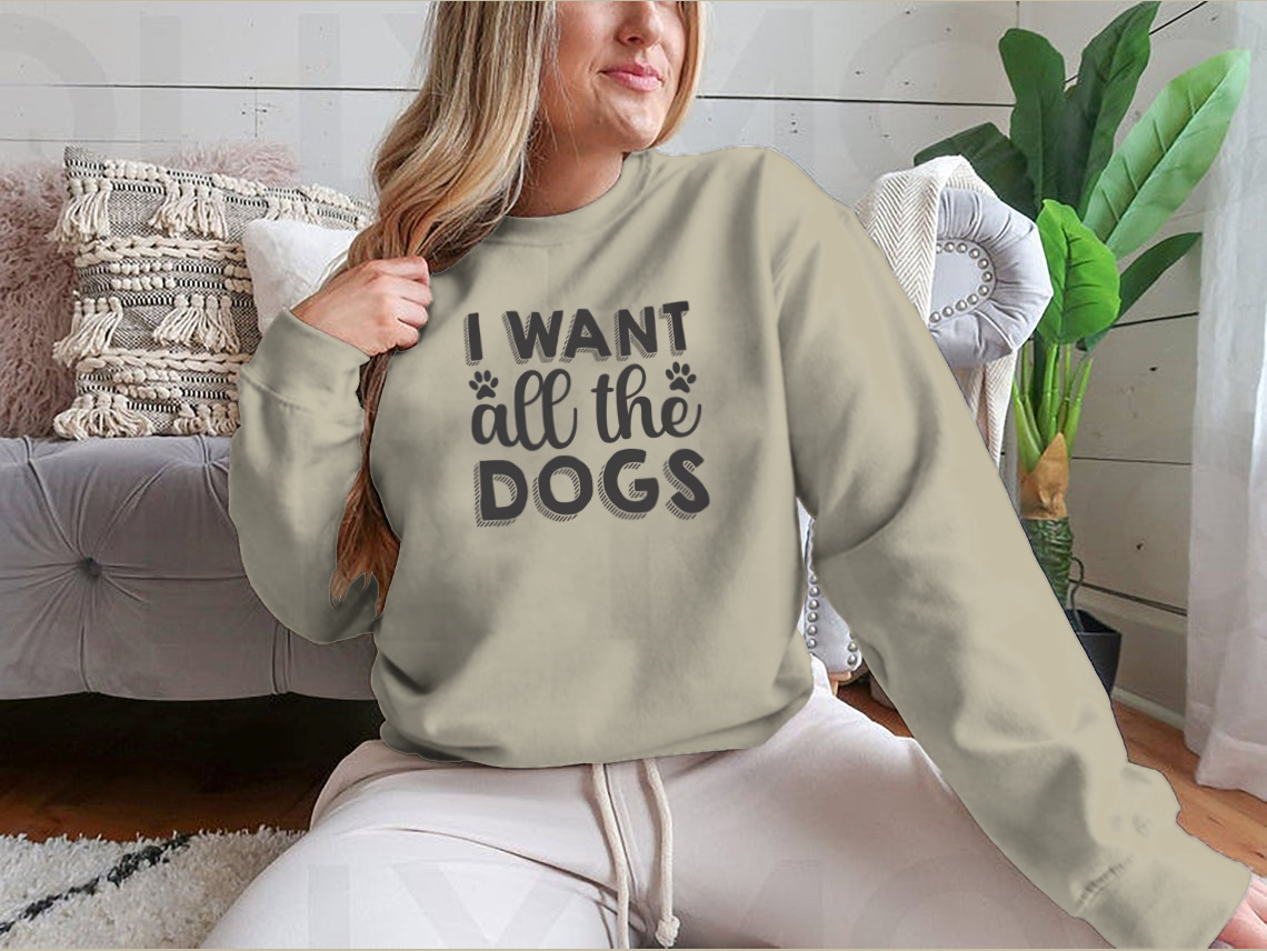 A hand-drawn inspirational quote shirt featuring 'I Want All The Dogs', made from 100% cotton, showcasing a classic fit and midweight fabric.