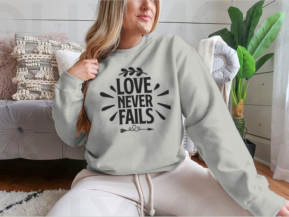 A collection of 'Love Never Fails' motivational T-shirts in various colors and sizes, showcasing their comfortable fabric and inspiring quotes.