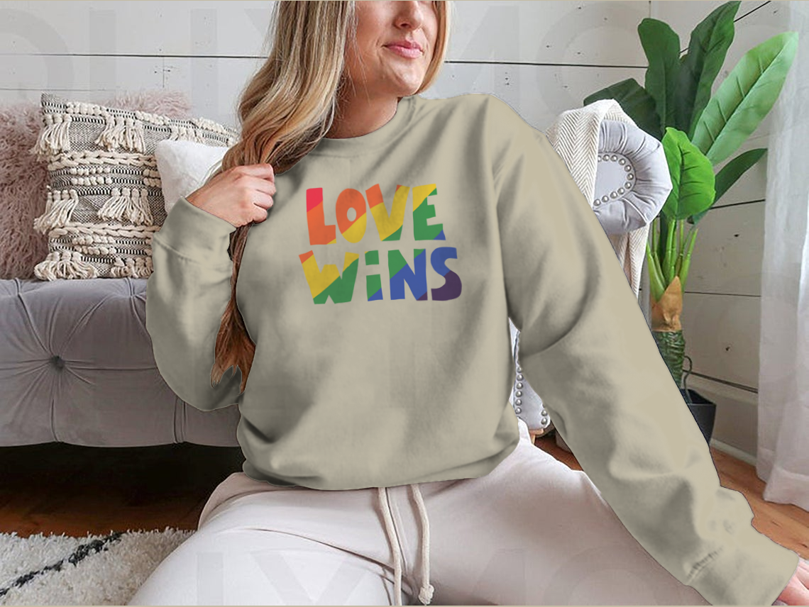 A stylish shirt featuring 'Love Wins' lettering with a vibrant rainbow design, made from soft cotton fabric.