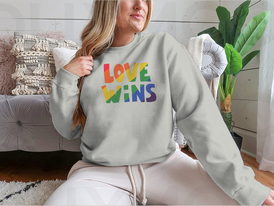 A stylish shirt featuring 'Love Wins' lettering with a vibrant rainbow design, made from soft cotton fabric.