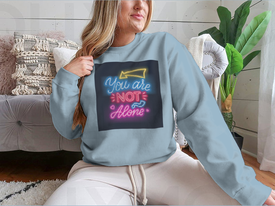 A vibrant sweatshirt featuring neon lettering that reads 'You're Not Alone', showcasing a classic fit and comfortable fabric.