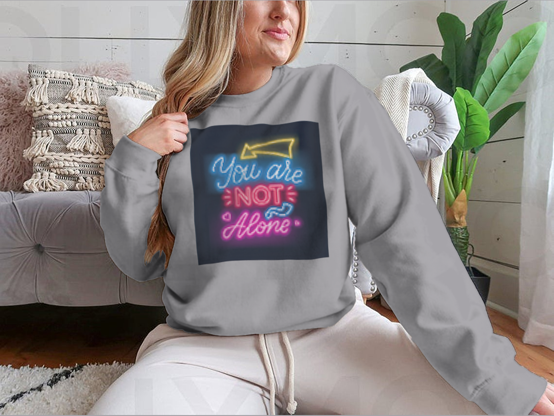 A vibrant sweatshirt featuring neon lettering that reads 'You're Not Alone', showcasing a classic fit and comfortable fabric.