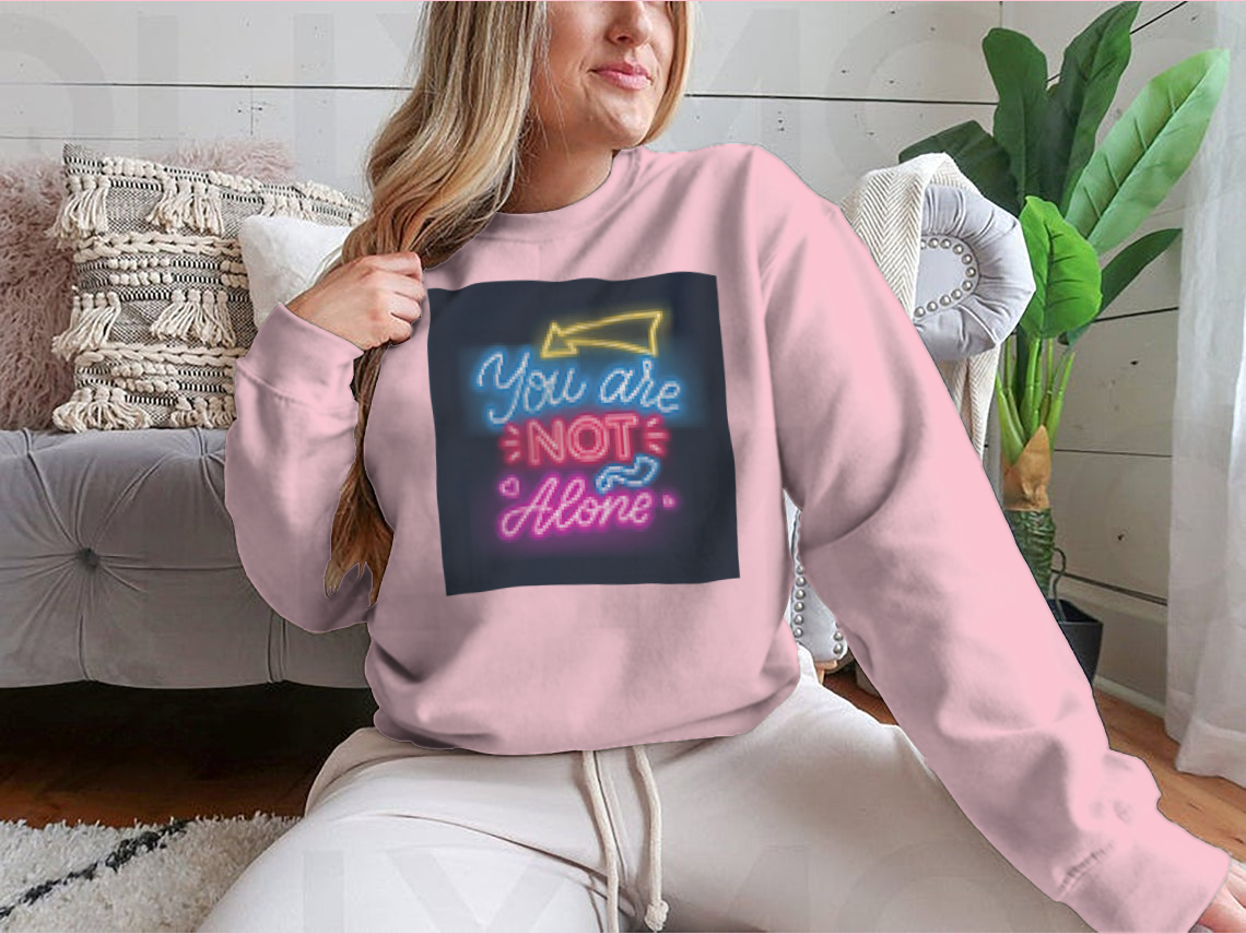 A vibrant sweatshirt featuring neon lettering that reads 'You're Not Alone', showcasing a classic fit and comfortable fabric.