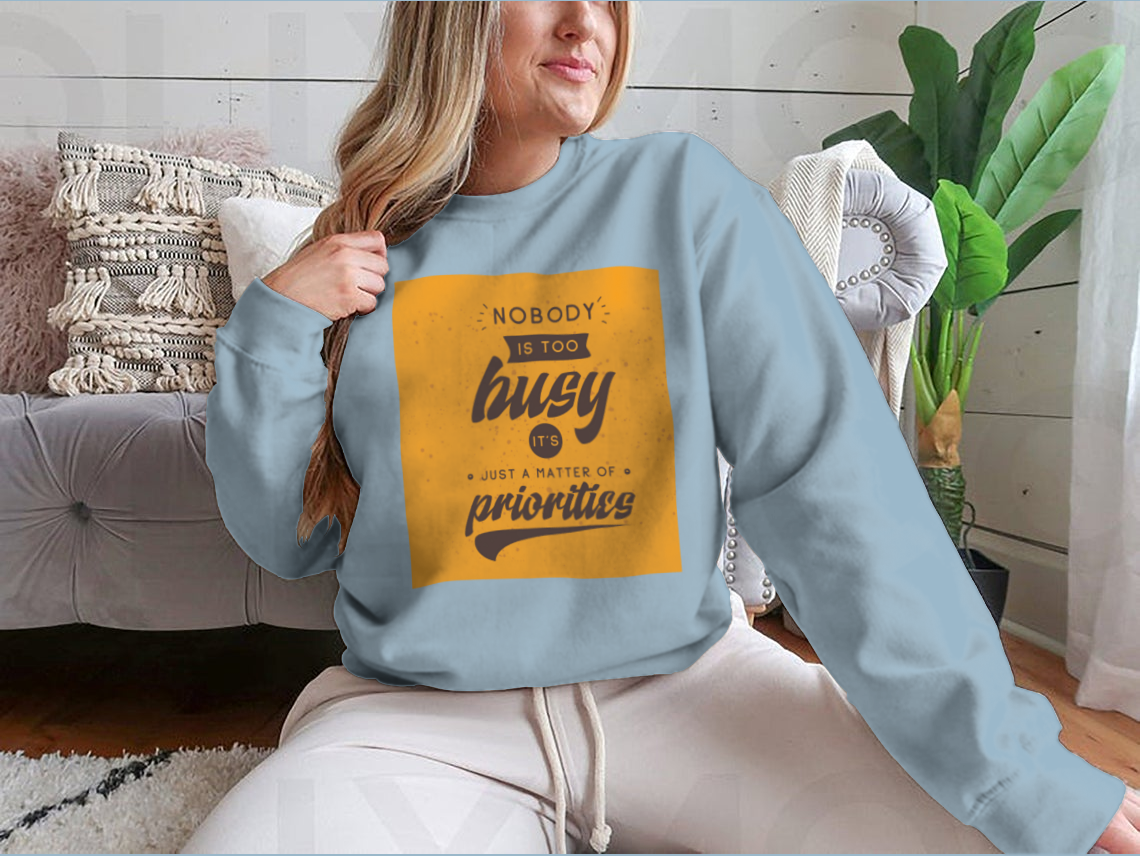 A motivational T-shirt featuring the quote 'Nobody Is Too Busy It's Just A Matter Of Priorities' in stylish typography, perfect for inspiring wearers.