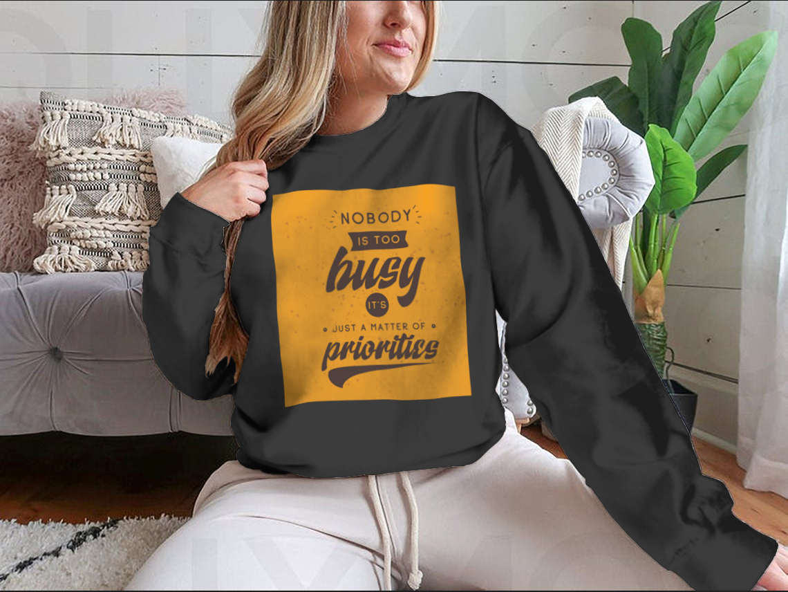A motivational T-shirt featuring the quote 'Nobody Is Too Busy It's Just A Matter Of Priorities' in stylish typography, perfect for inspiring wearers.