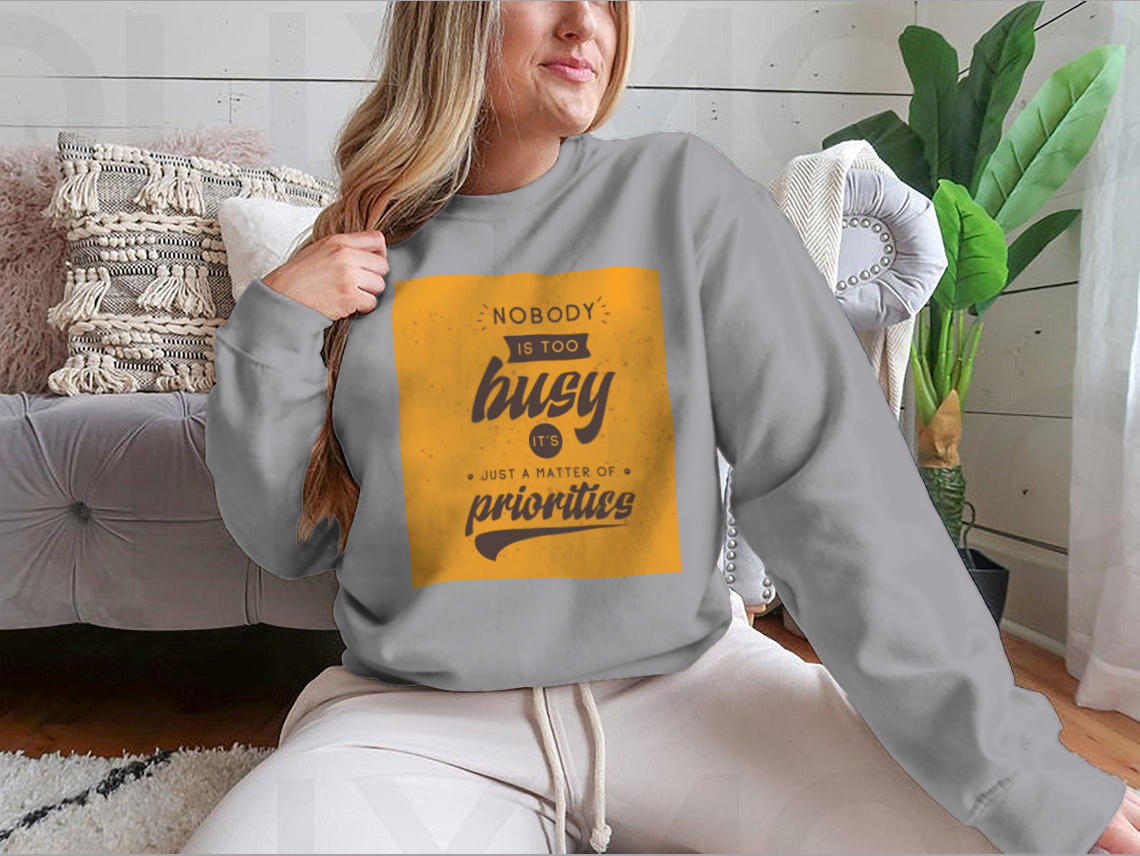 A motivational T-shirt featuring the quote 'Nobody Is Too Busy It's Just A Matter Of Priorities' in stylish typography, perfect for inspiring wearers.