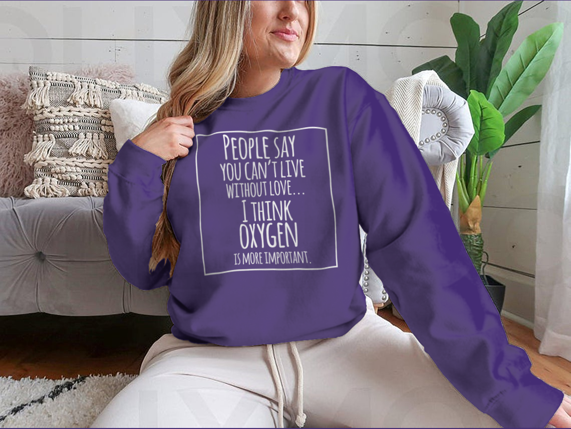 A humorous t-shirt featuring the quote 'People Say You Can't Live Without Love I Think Oxygen Is More' in a stylish design.