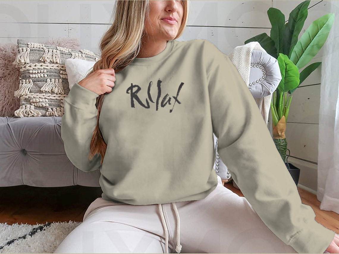 Relax Word Shirt featuring hand-drawn typography design, made from 100% cotton, displayed on a neutral background.