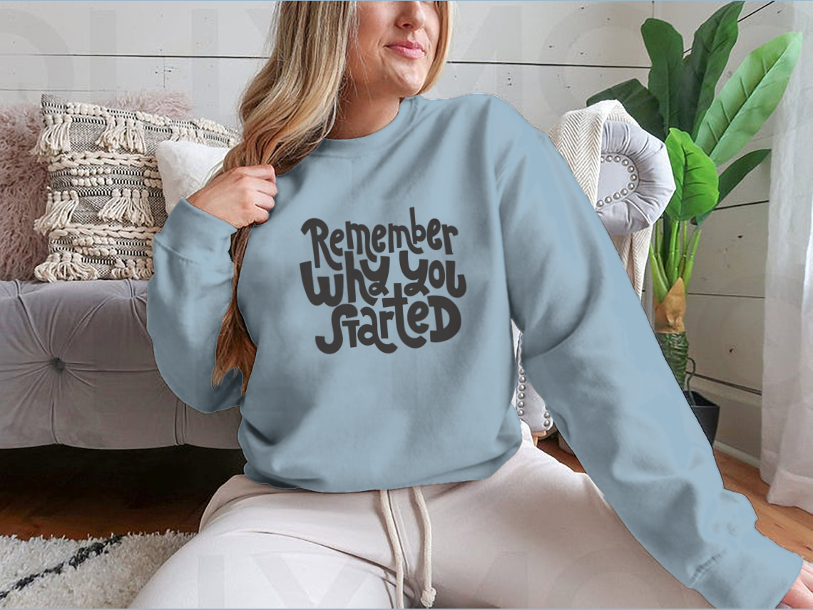 A cozy sweatshirt featuring the motivational quote 'Remember Why You Started', designed for comfort and style.