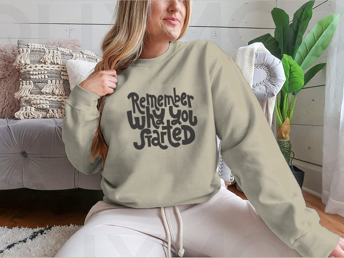 A cozy sweatshirt featuring the motivational quote 'Remember Why You Started', designed for comfort and style.