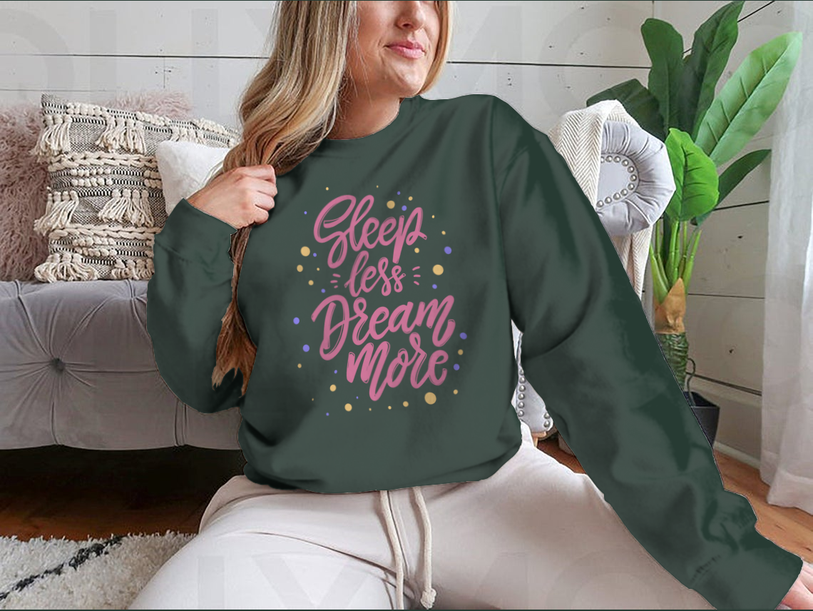 A stylish T-shirt featuring the phrase 'Sleep Less Dream More' in cute lettering, made from soft cotton fabric.