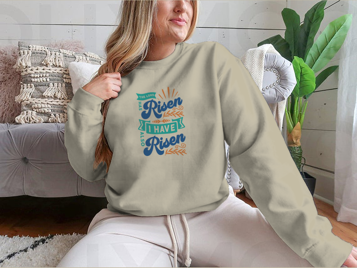 A motivational apparel featuring the phrase 'The Lord Has Risen I Have Also Risen' in a stylish design, made from a comfortable cotton/polyester blend.
