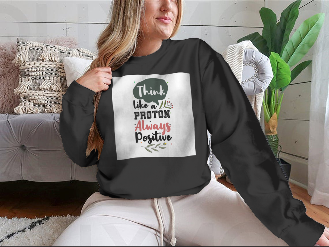 A premium motivational quote shirt featuring the phrase 'Think Like A Proton Always Positive' in a stylish design, made from soft cotton fabric.