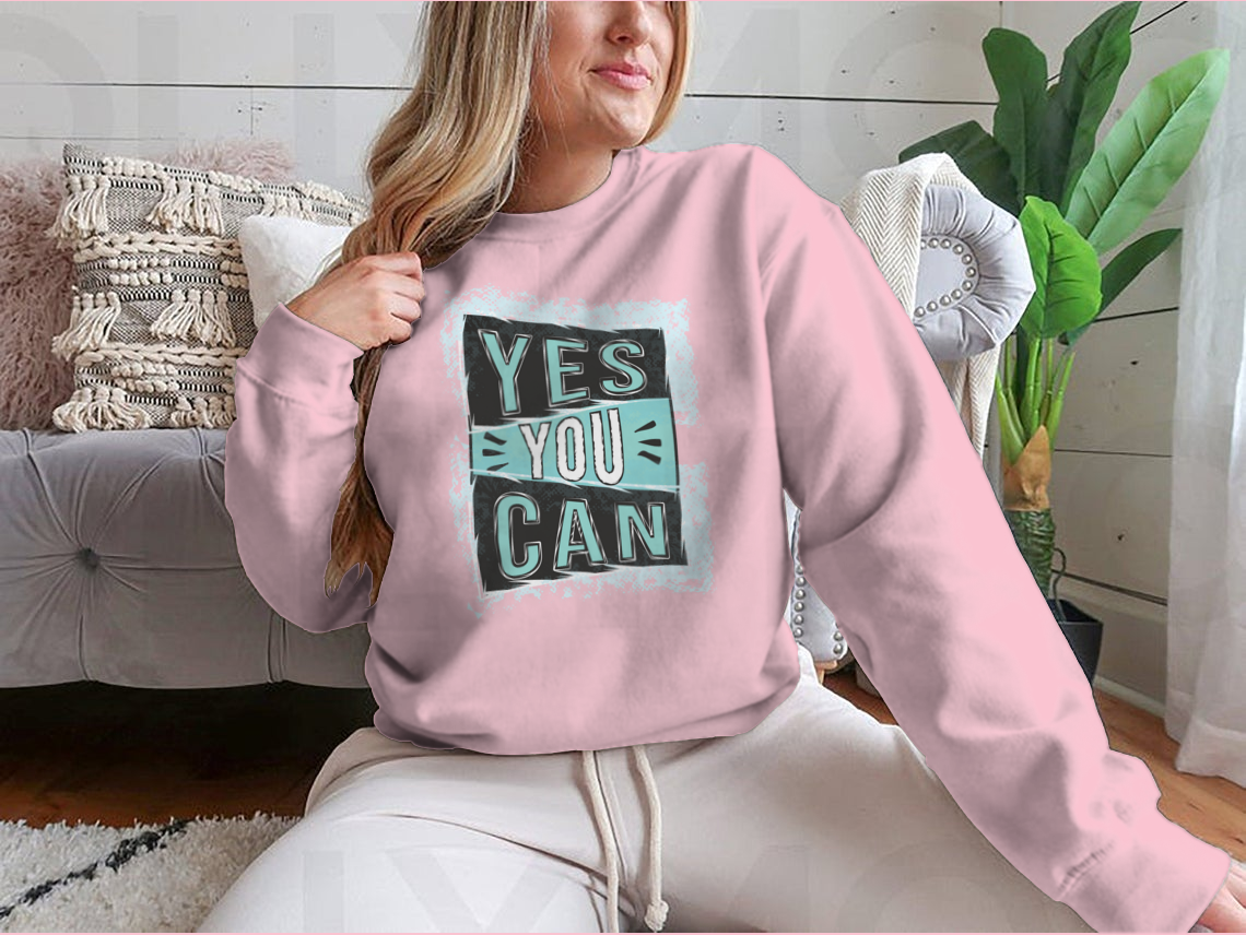 A cozy sweatshirt featuring the inspirational quote 'Yes You Can!' designed for comfort and style.