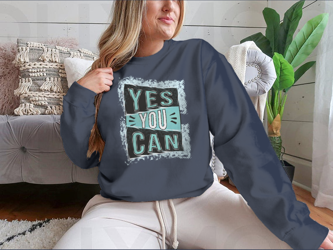A cozy sweatshirt featuring the inspirational quote 'Yes You Can!' designed for comfort and style.