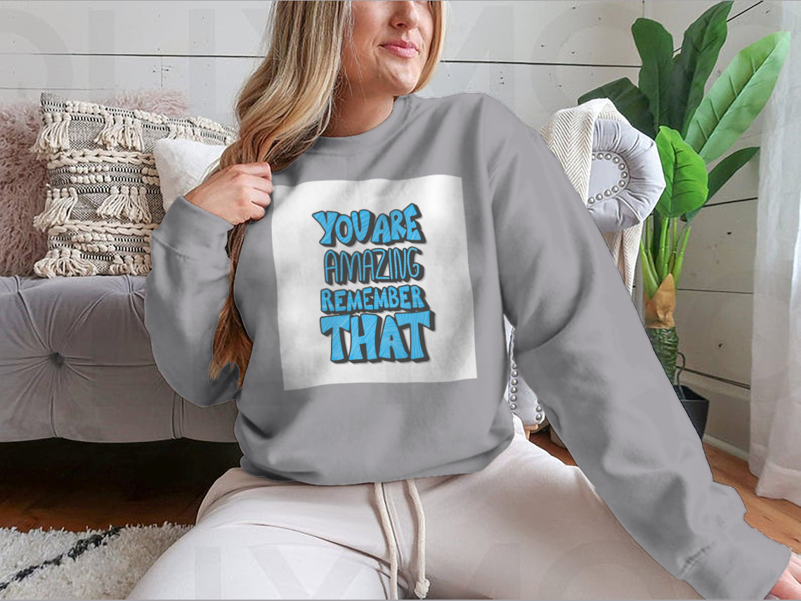 A cozy sweatshirt featuring the motivational quote 'You Are Amazing Remember That' in stylish typography, perfect for casual wear.