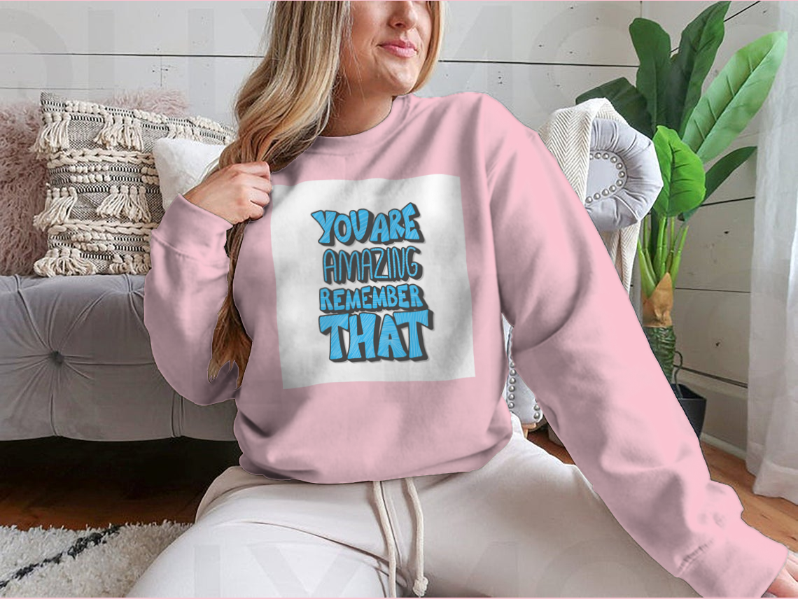 A cozy sweatshirt featuring the motivational quote 'You Are Amazing Remember That' in stylish typography, perfect for casual wear.