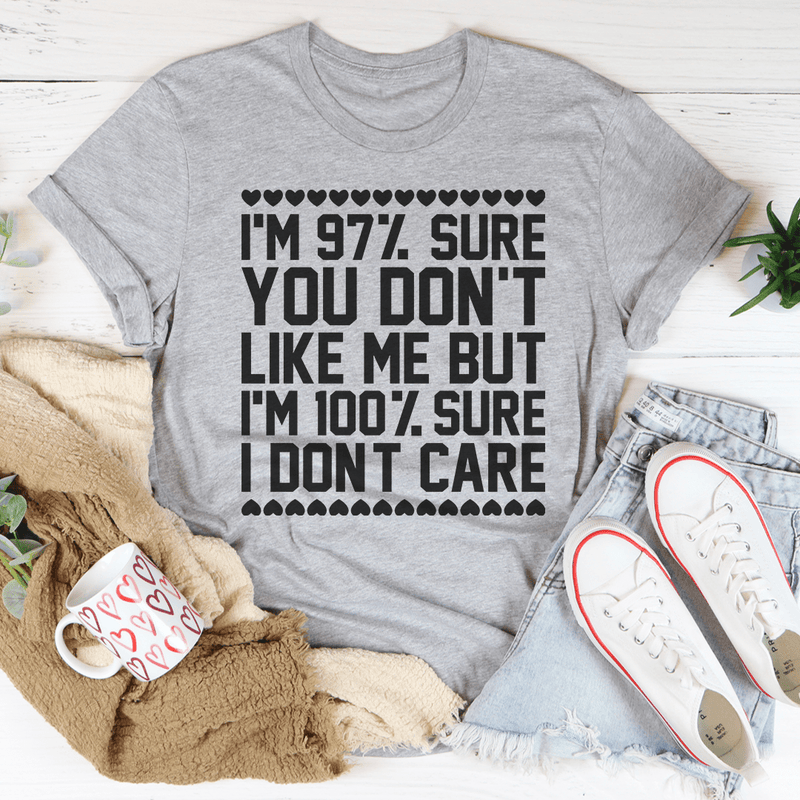 A stylish black t-shirt with the phrase '97% Sure You Don't Like Me But 100% Sure I Don't Care' printed in bold white letters.