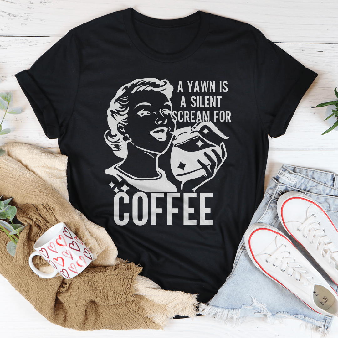 A comfortable t-shirt featuring the phrase 'A Yawn Is A Silent Scream For Coffee' printed on it, made from soft ring-spun cotton.