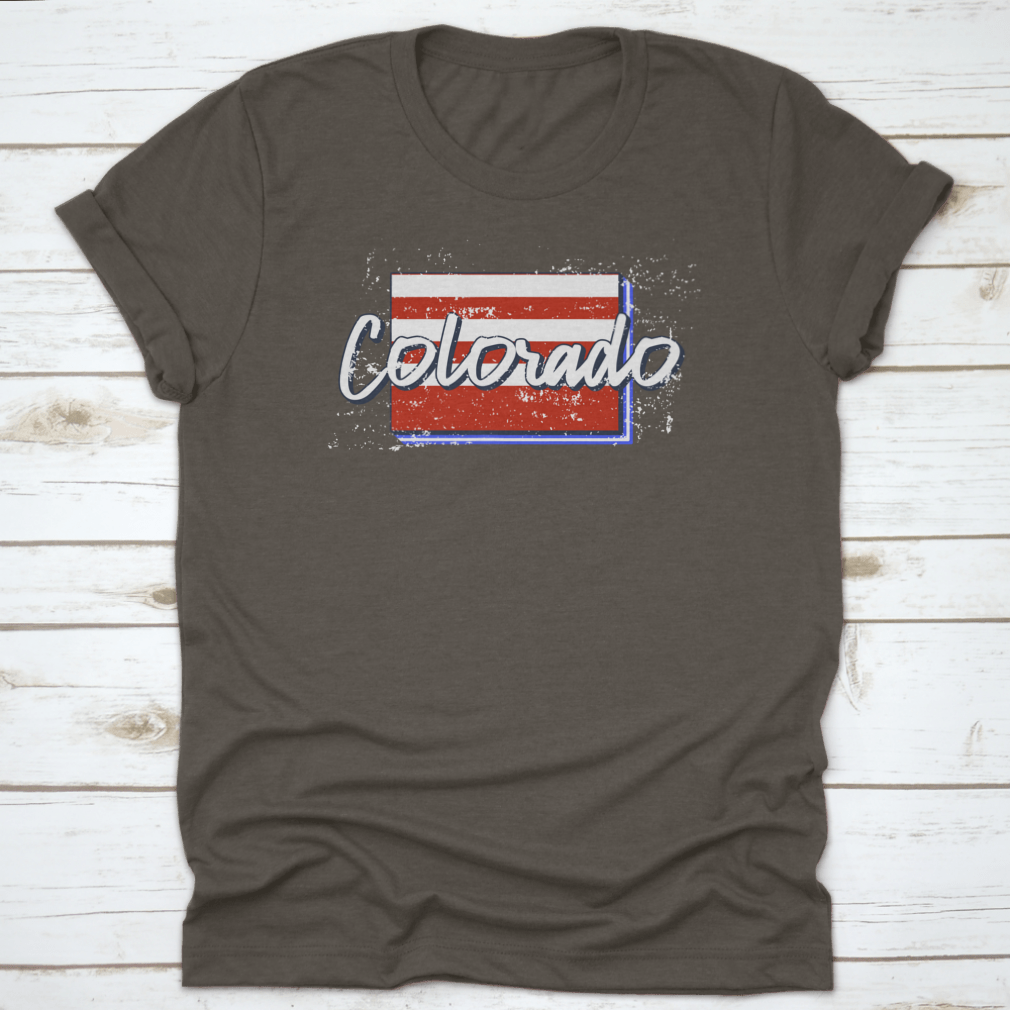 A stylish t-shirt featuring a grunge-style American flag design overlaid on a Colorado state map, showcasing patriotism and state pride.
