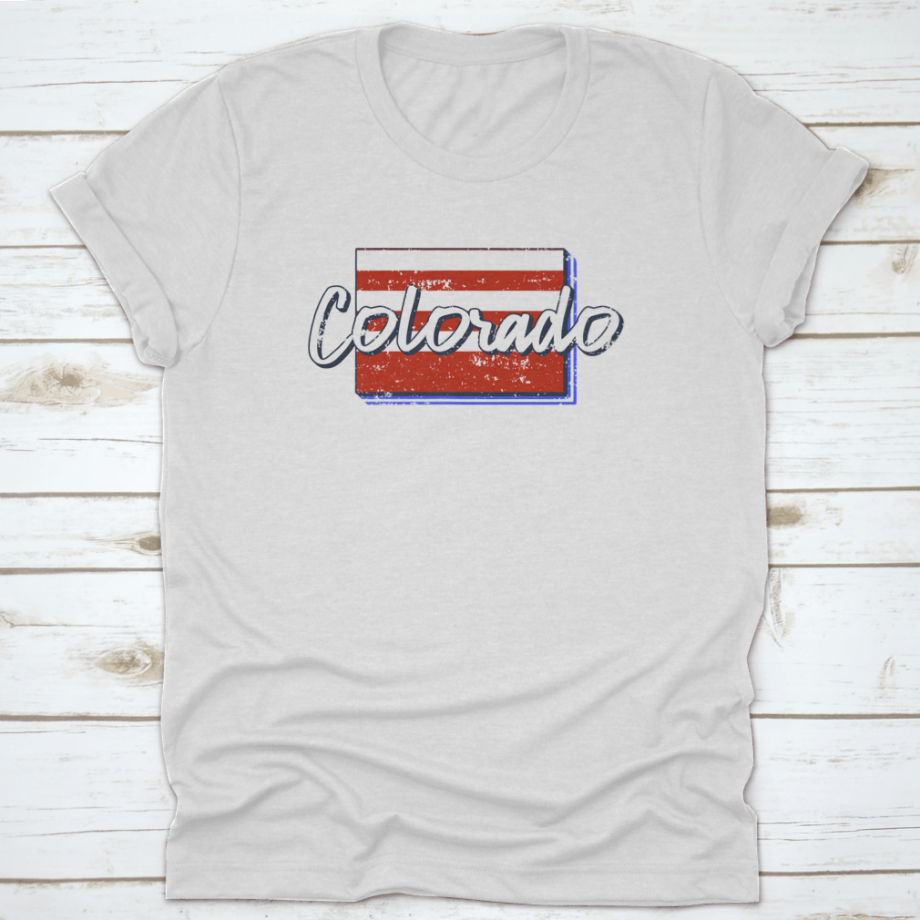 A stylish t-shirt featuring a grunge-style American flag design overlaid on a Colorado state map, showcasing patriotism and state pride.