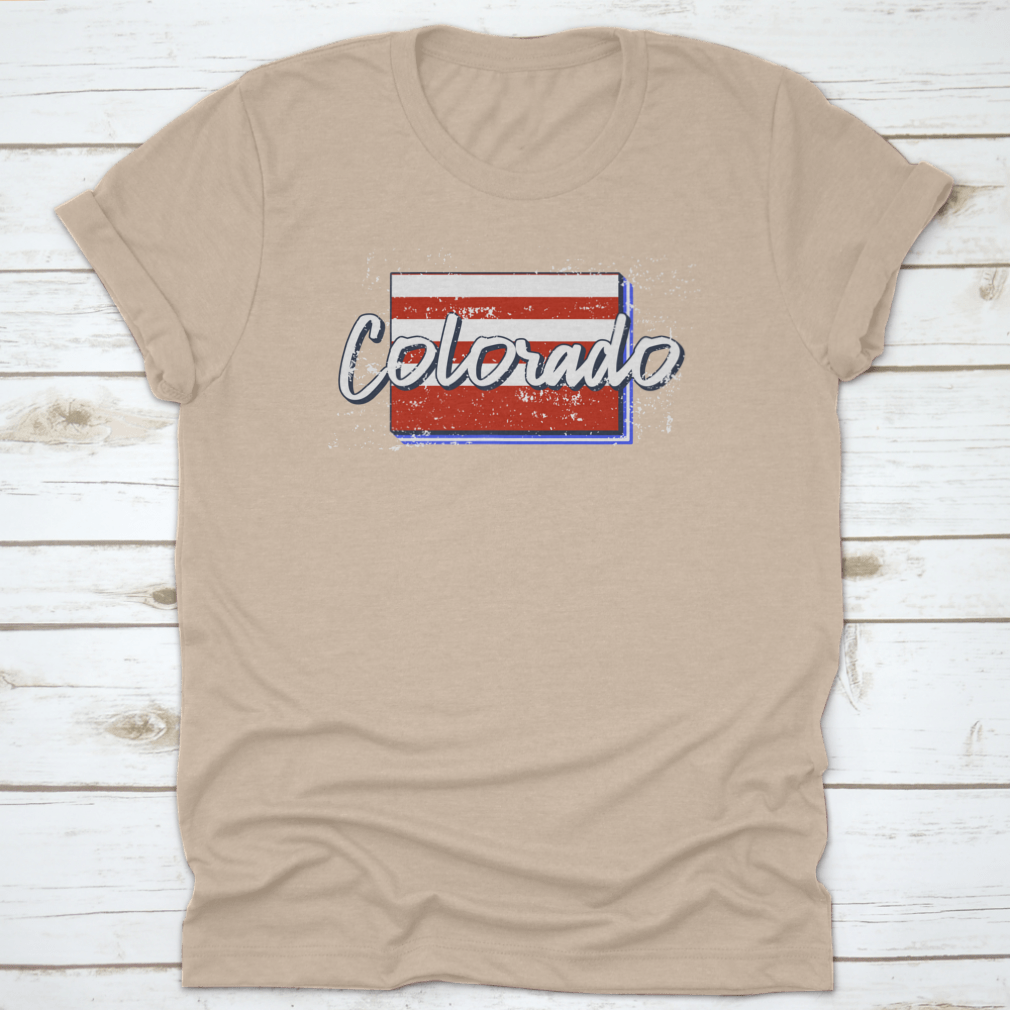 A stylish t-shirt featuring a grunge-style American flag design overlaid on a Colorado state map, showcasing patriotism and state pride.