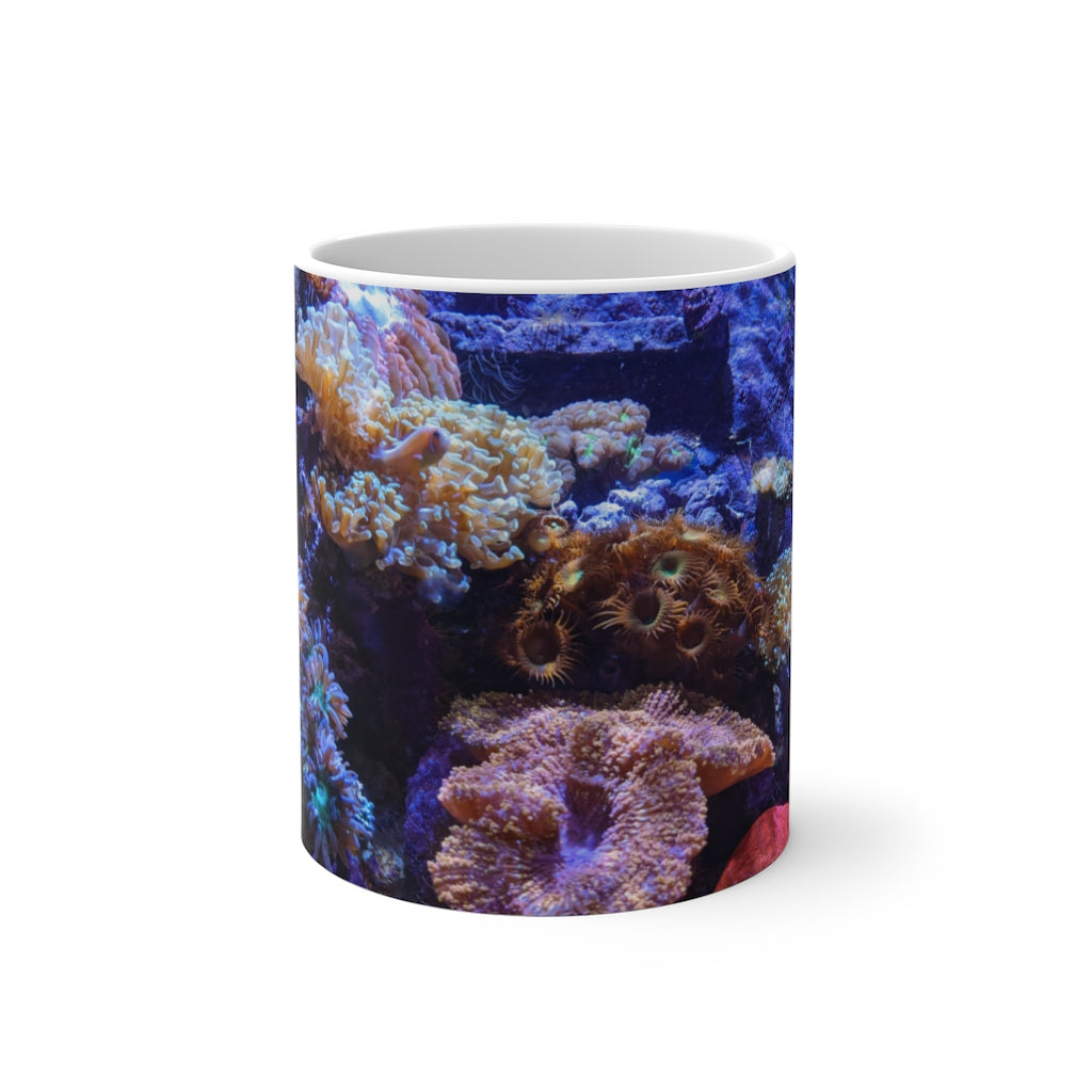 A white ceramic color changing mug displaying vibrant colors when filled with hot liquid, featuring a C-handle and rounded corners.