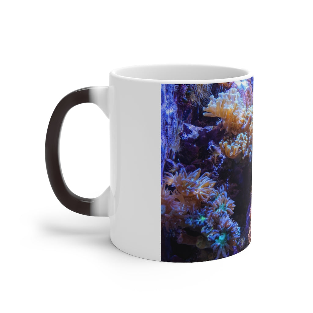 A white ceramic color changing mug displaying vibrant colors when filled with hot liquid, featuring a C-handle and rounded corners.