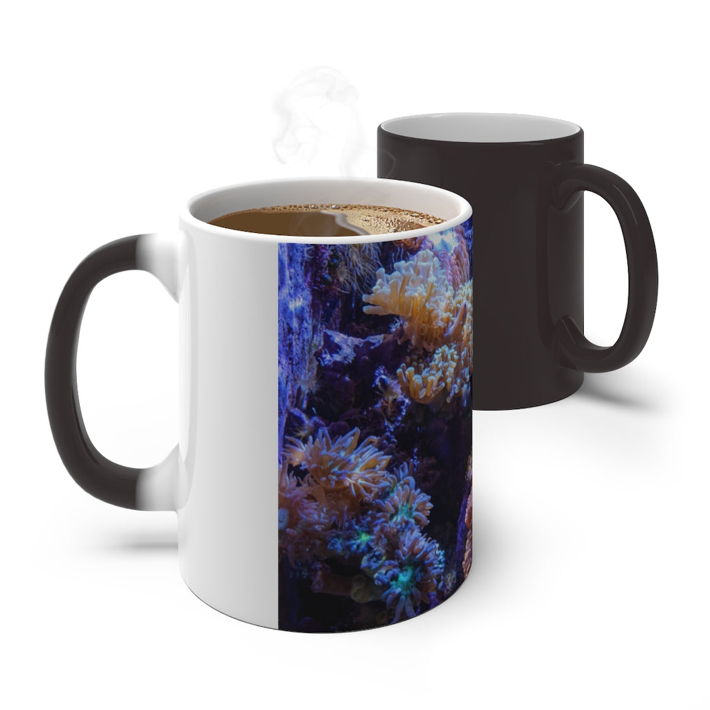 A white ceramic color changing mug displaying vibrant colors when filled with hot liquid, featuring a C-handle and rounded corners.