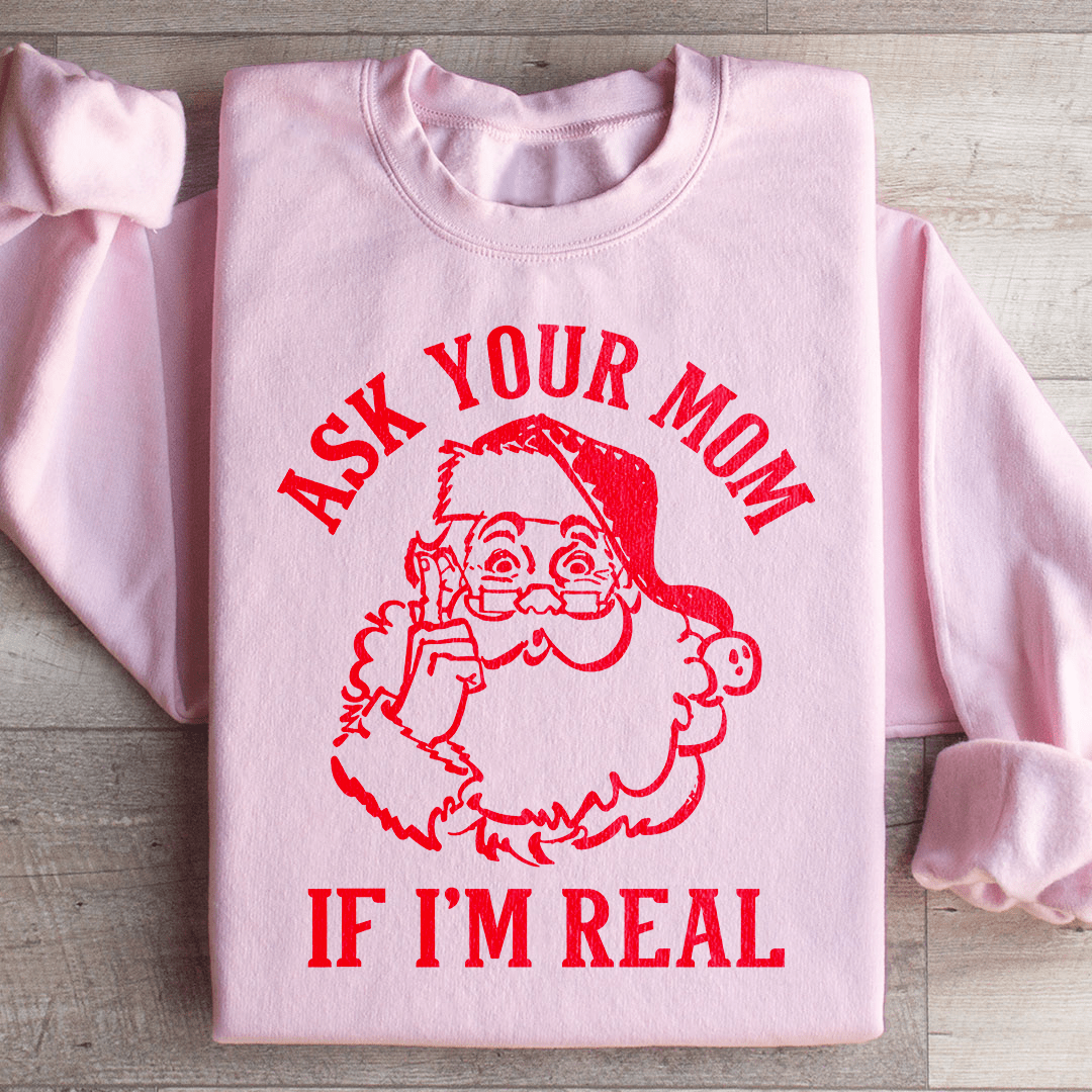 A cozy sweatshirt featuring the phrase 'Ask Your Mom If I'm Real' in a festive design, perfect for holiday celebrations.