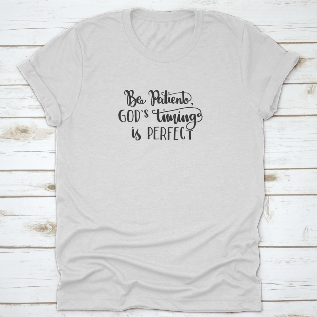 A modern hand lettered quote shirt featuring 'Be Patient God's Timing Is Perfect' in stylish typography, made from soft cotton fabric.
