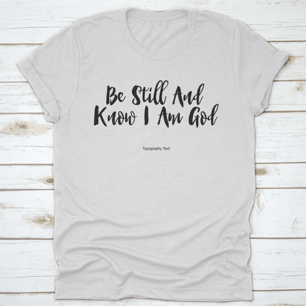 A comfortable T-shirt featuring the bold typography quote 'Be Still And Know I Am God', showcasing its inspirational design and quality fabric.