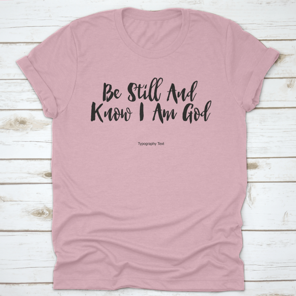 A comfortable T-shirt featuring the bold typography quote 'Be Still And Know I Am God', showcasing its inspirational design and quality fabric.
