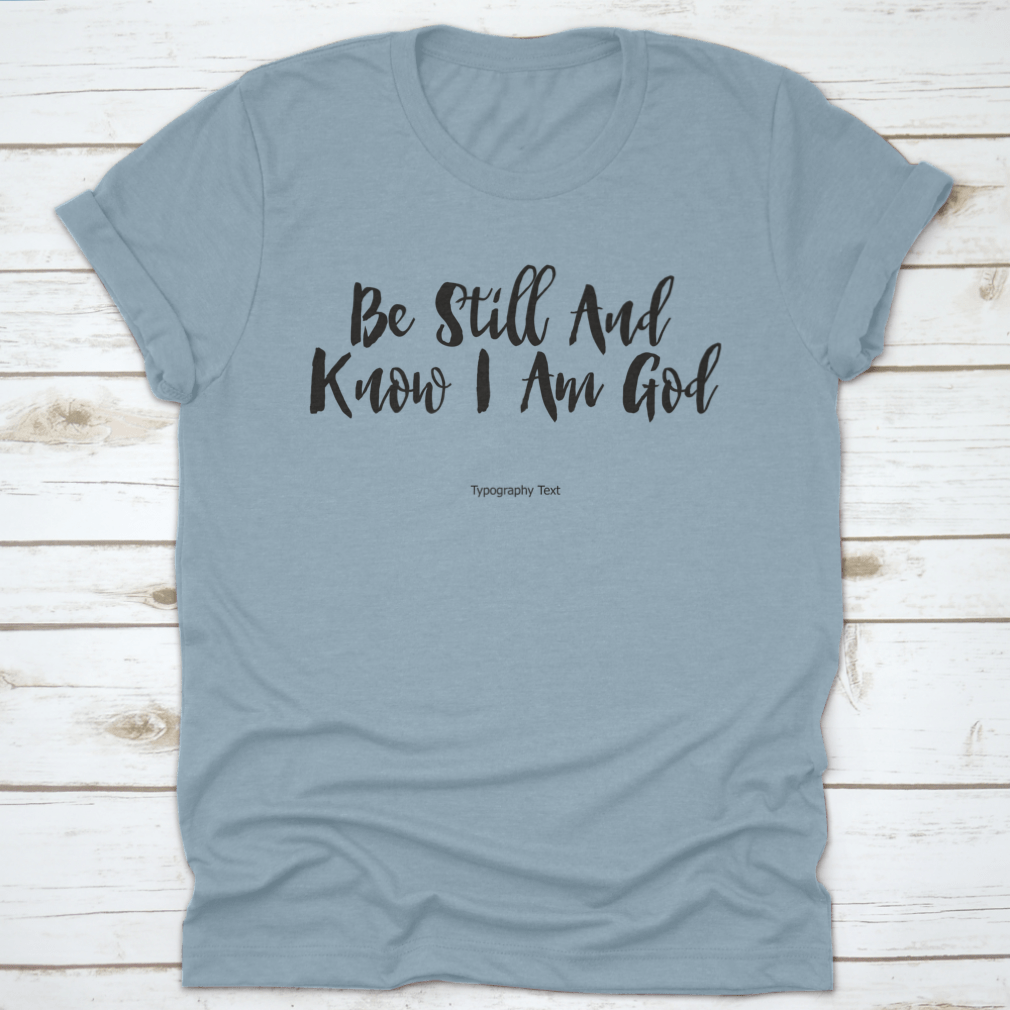 A comfortable T-shirt featuring the bold typography quote 'Be Still And Know I Am God', showcasing its inspirational design and quality fabric.