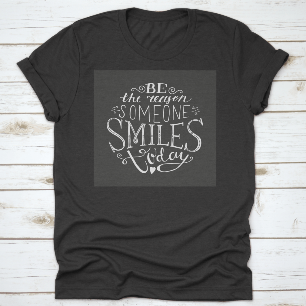A soft cotton t-shirt featuring the uplifting phrase 'Be The Reason Someone Smiles Today' in a stylish font, perfect for casual wear.
