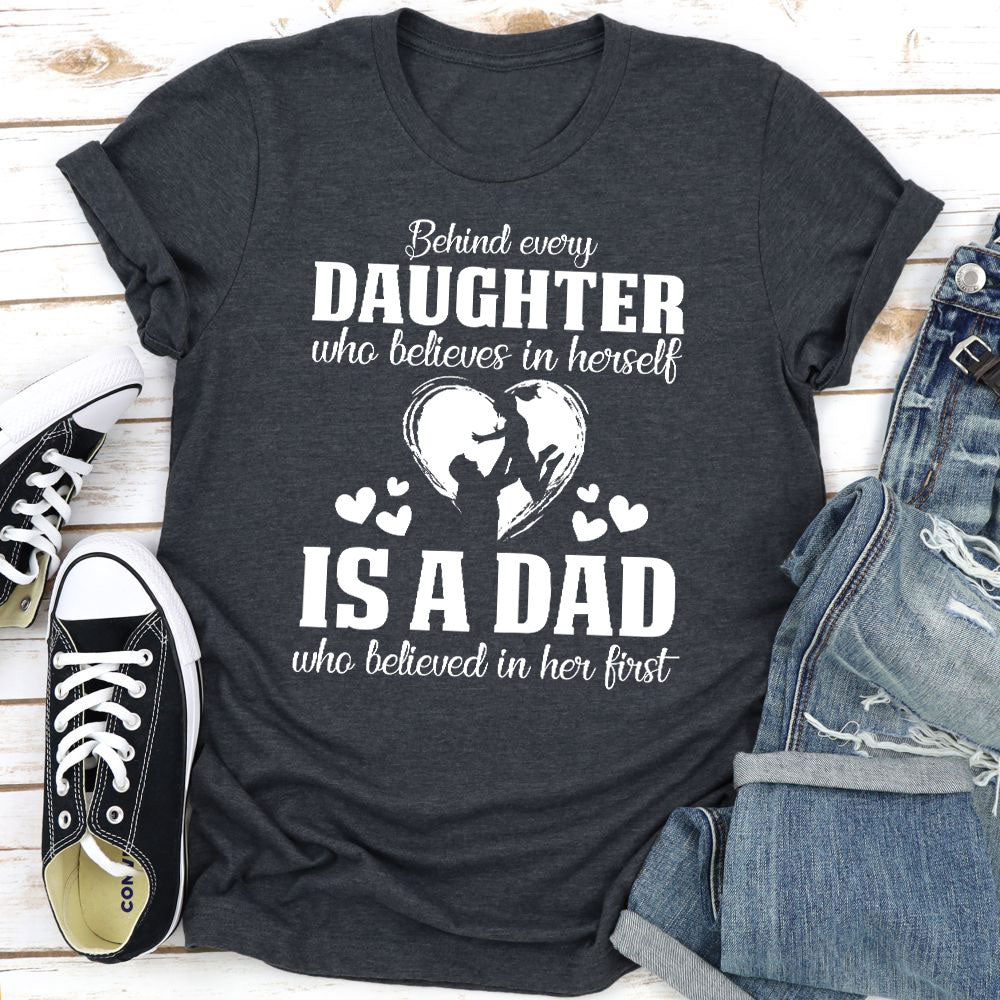 A comfortable t-shirt featuring the phrase 'Behind Every Daughter Who Believes In Herself Is A Dad Who Believed In', made from soft cotton.