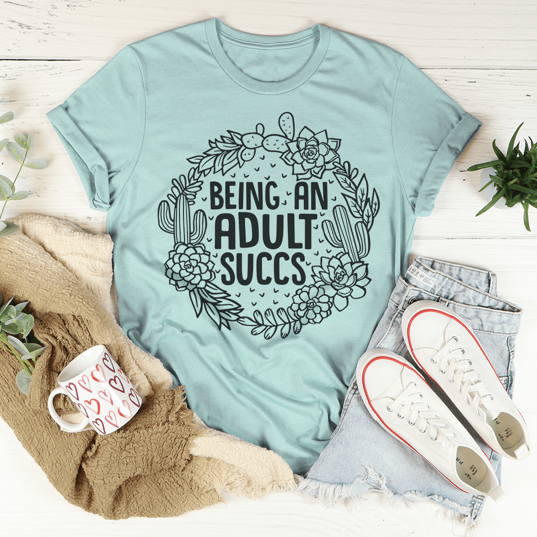 Being An Adult Succs T-Shirt in various colors, showcasing its soft cotton fabric and humorous design.