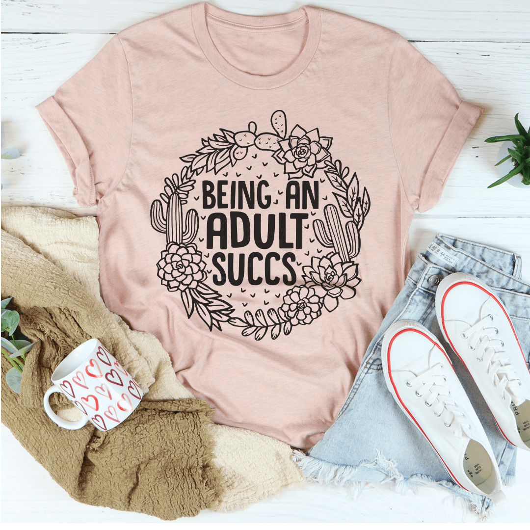 Being An Adult Succs T-Shirt in various colors, showcasing its soft cotton fabric and humorous design.