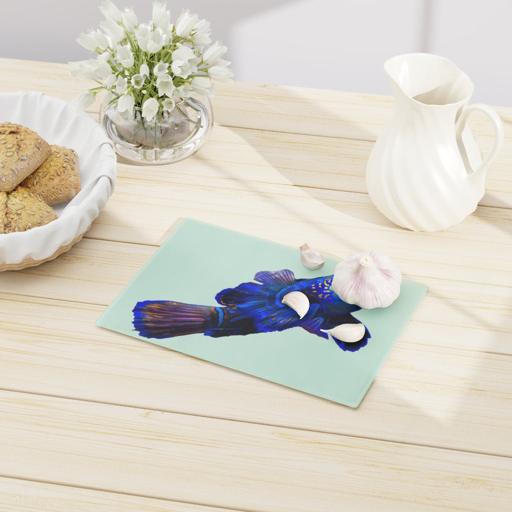 A stylish Blue Fish Cutting Board made of tempered glass, featuring a unique fish design and rubber dots for stability.