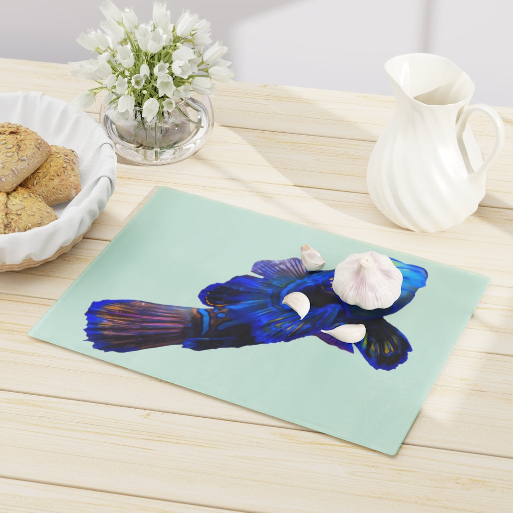 A stylish Blue Fish Cutting Board made of tempered glass, featuring a unique fish design and rubber dots for stability.