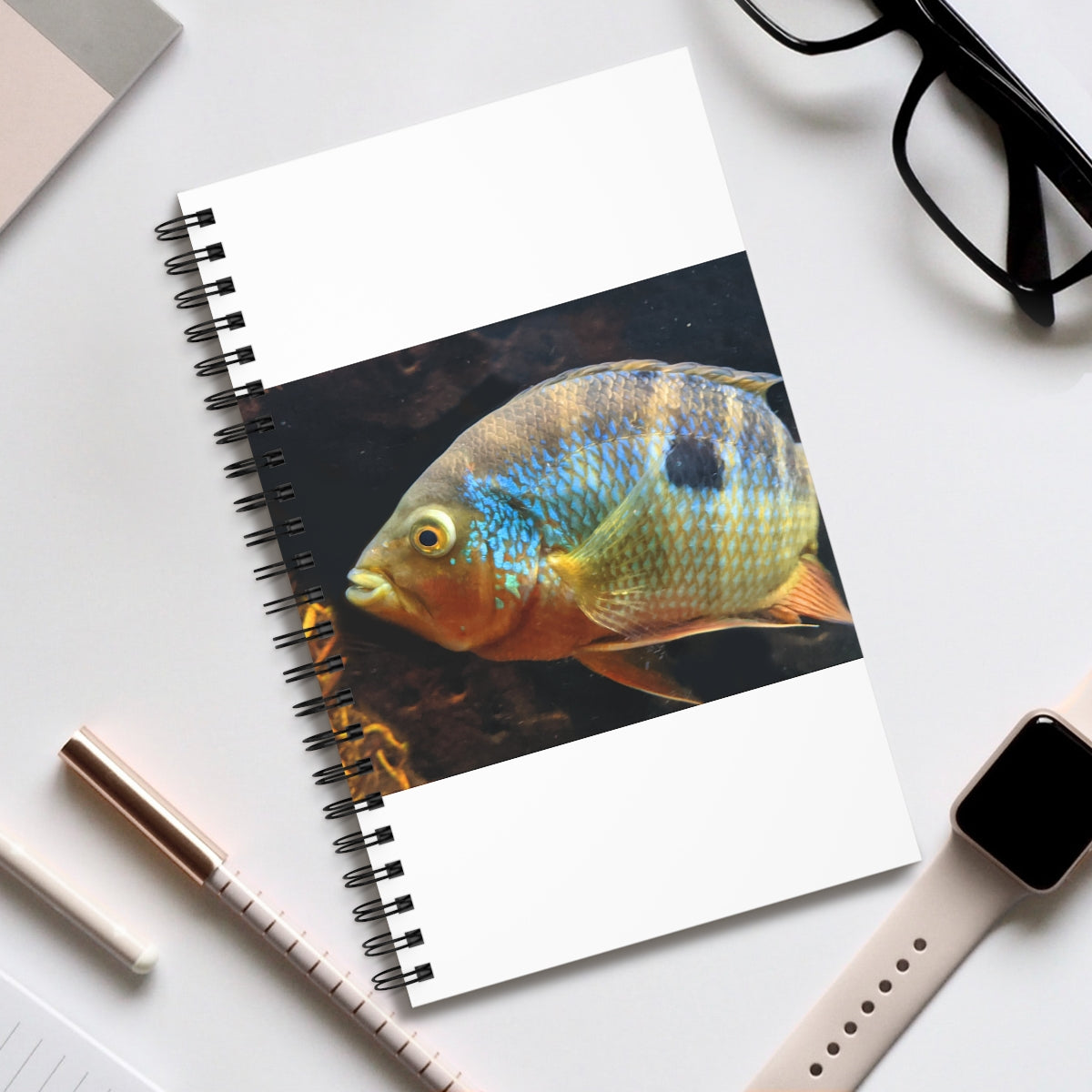 Brown and orange spiral journal featuring a fish design on the front cover, showcasing its vibrant colors and spiral binding.