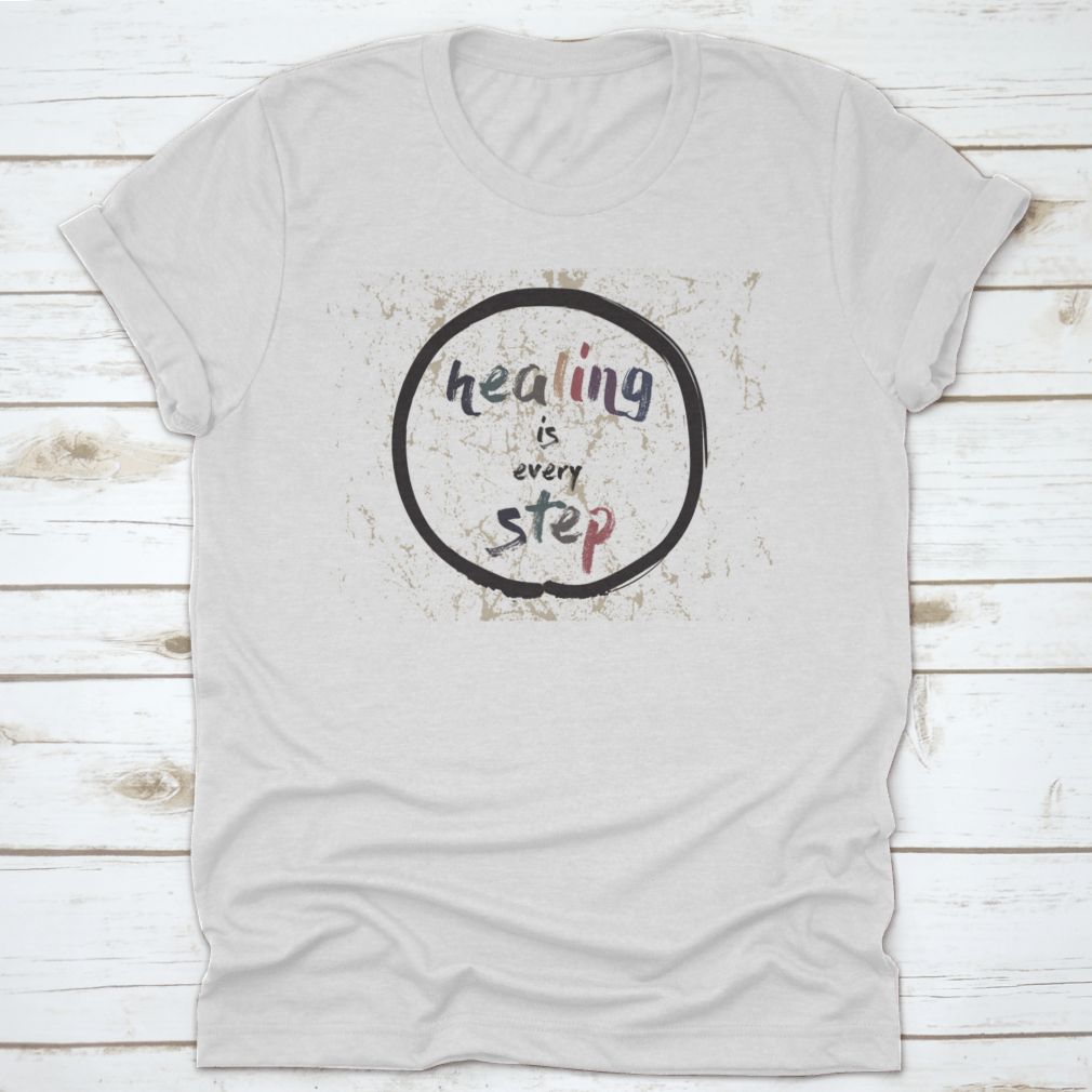 A soft cotton t-shirt featuring the inspirational quote 'Healing Is Every Step' in elegant calligraphy, perfect for casual wear.