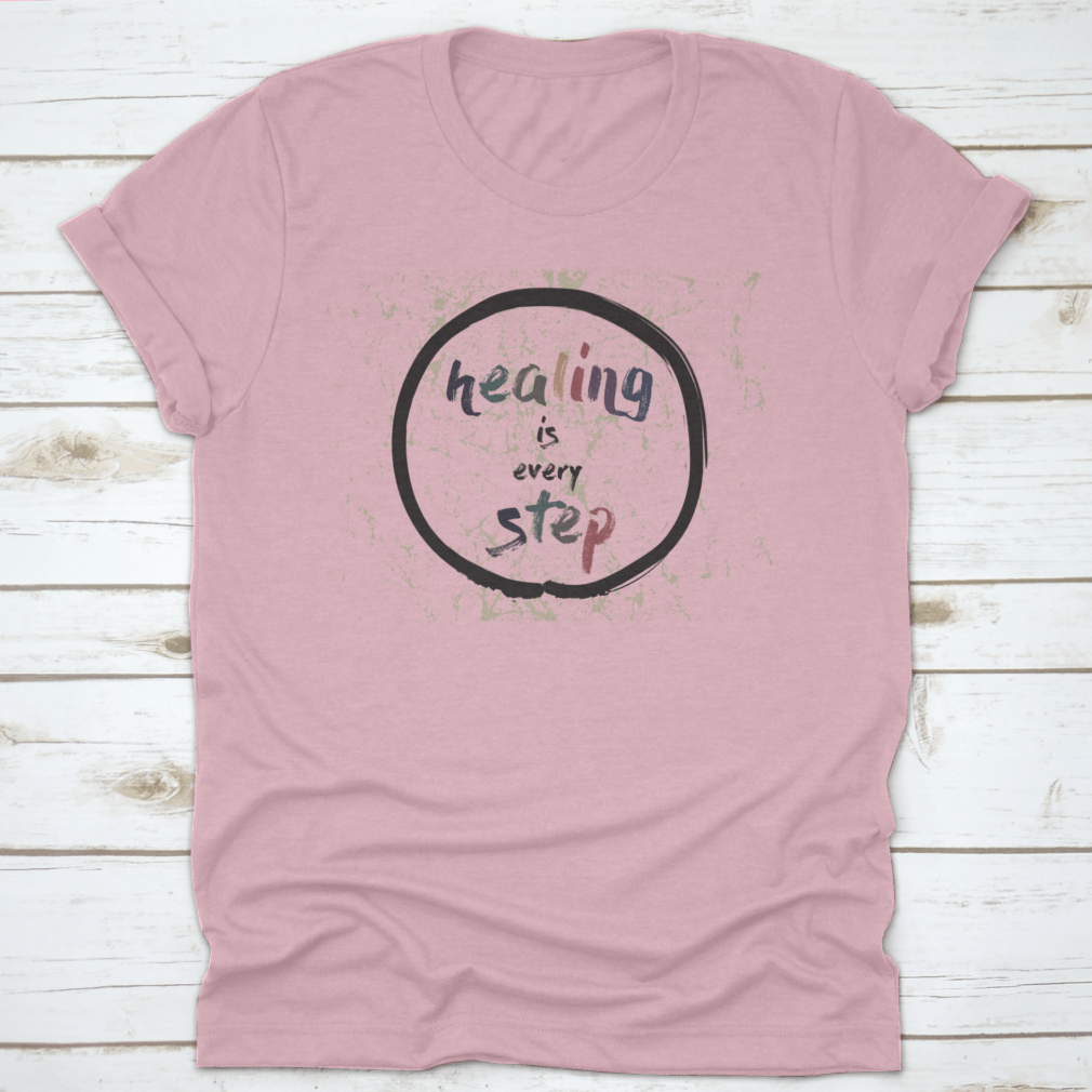 A soft cotton t-shirt featuring the inspirational quote 'Healing Is Every Step' in elegant calligraphy, perfect for casual wear.
