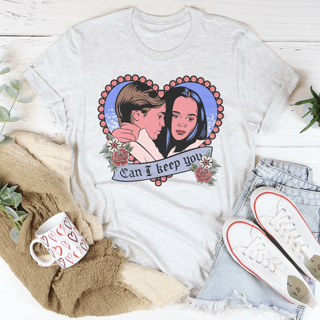 A stylish Halloween-themed tee featuring the phrase 'Can I Keep You' printed in vibrant colors on a soft cotton fabric.