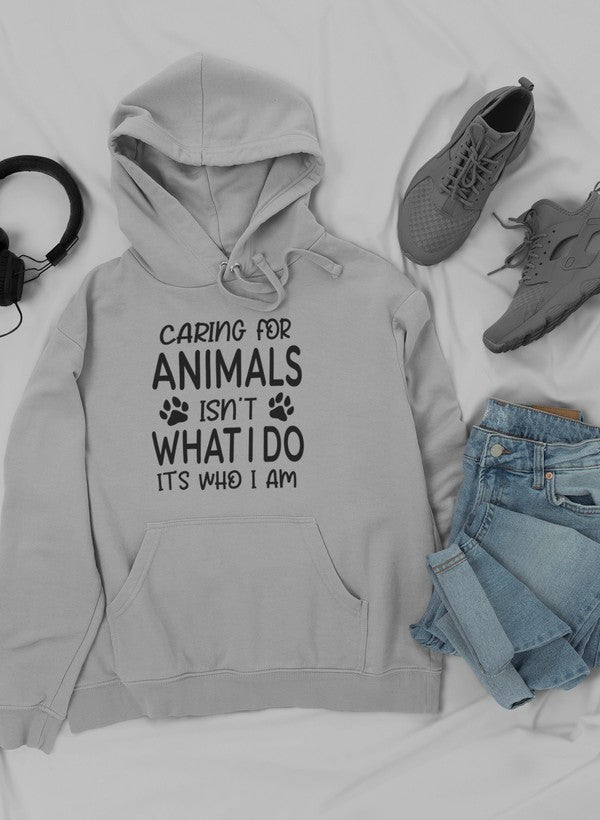 A cozy hoodie featuring the phrase 'Caring for Animals Isn't What I Do It's Who I Am', perfect for animal lovers.