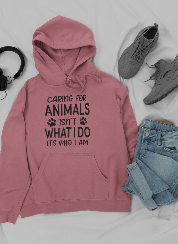 A cozy hoodie featuring the phrase 'Caring for Animals Isn't What I Do It's Who I Am', perfect for animal lovers.