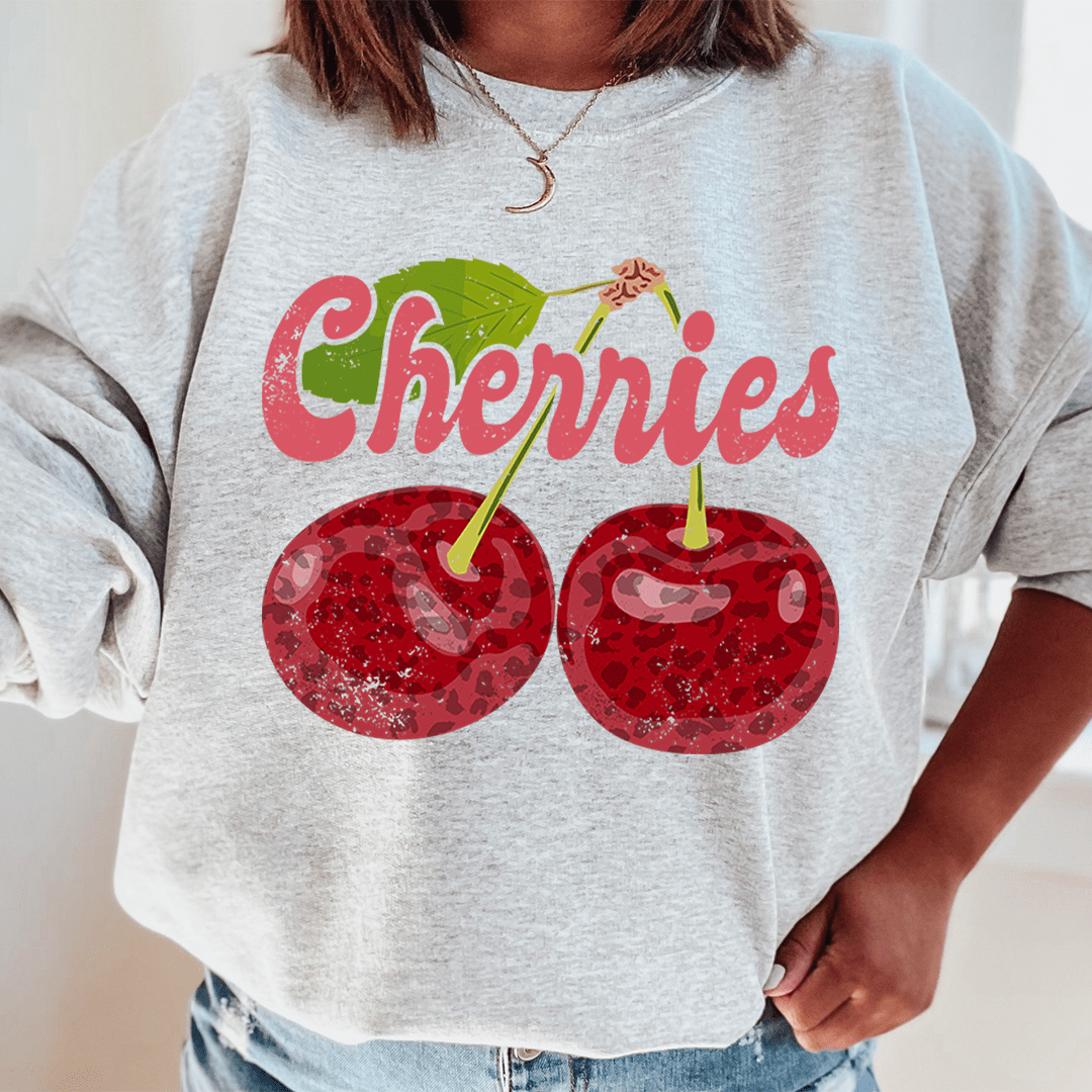 A cozy Cherries hoodie made from cotton/poly fleece blend, featuring adjustable banded cuffs and unique artistic designs.